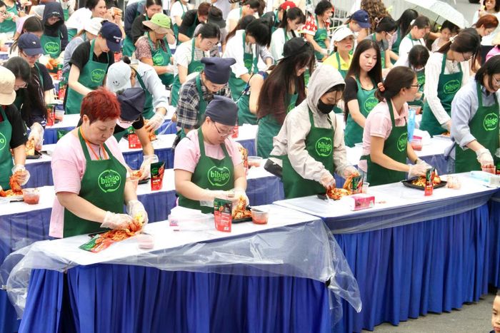 Đông đảo người dân, từ bạn trẻ đến các bà, các mẹ, chăm chú tự tay trộn gia vị, ướp từng lớp cải thảo theo hướng dẫn.