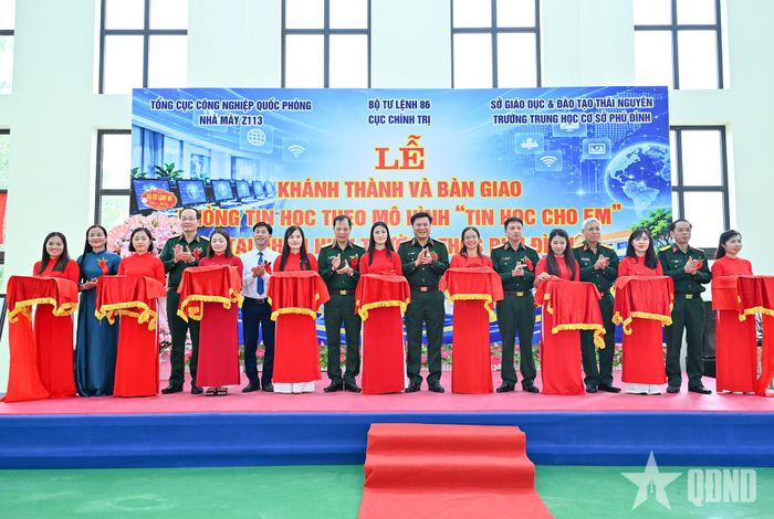 Các đại biểu thực hiện nghi thức cắt băng khánh thành phòng tin học tặng Trường THCS Phú Đình.