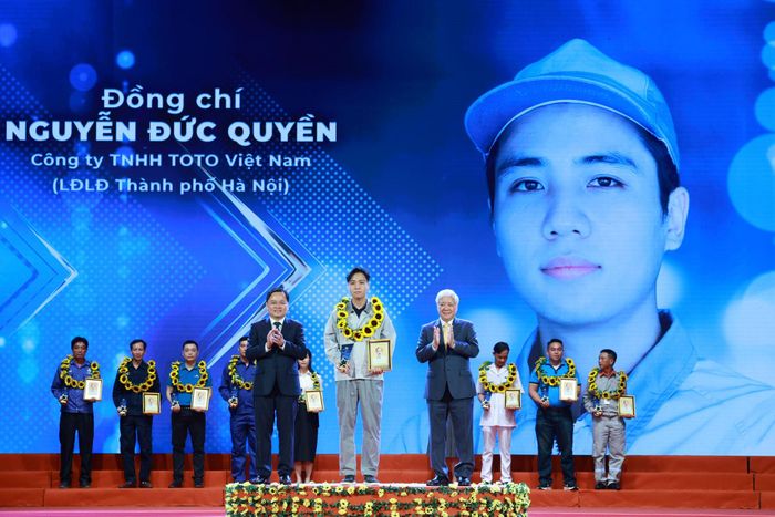 Đồng chí Đỗ Văn Chiến và đồng chí Nguyễn Anh Tuấn trao biểu trưng của chương trình tặng công nhân Nguyễn Đức Quyền, Công ty TNHH TOTO Việt Nam (LĐLĐ Thành phố Hà Nội). Ảnh: HẢI NGUYỄN 