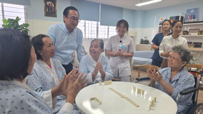 Lãnh đạo Bệnh viện Phục hồi chức năng và Điều trị bệnh nghề nghiệp TPHCM trò chuyện cùng người cao tuổi. Ảnh: THÀNH AN