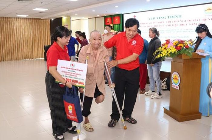 Các nhân viên Hội Chữ thập đỏ Việt Nam TP.HCM hỗ trợ người khuyết tật di chuyển khi chương trình kết thúc