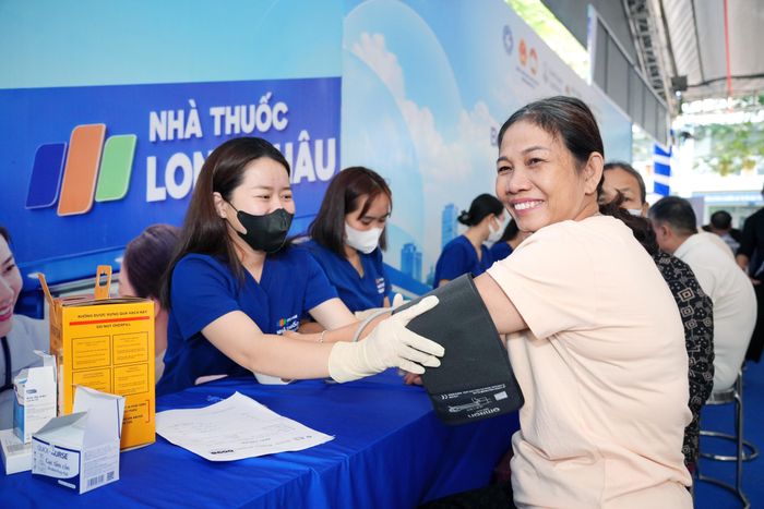  Nhân viên y tế đo huyết áp cho người dân 