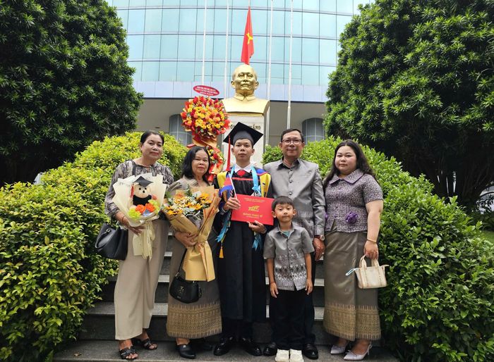  Tân thạc sĩ Nuth Sokrite chụp ảnh cùng gia đình tại tượng đài Chủ tịch Tôn Đức Thắng trong khuôn viên TDTU, ngày 23-10. 
