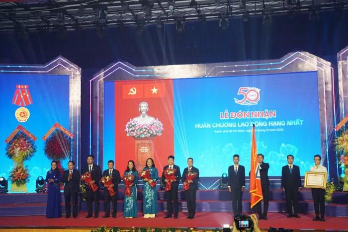 Phó Thủ tướng Lê Tiến Châu và Thứ trưởng Bộ GD&ĐT Nguyễn Thị Quyên Thanh chúc mừng tập thể nhà trường nhận Huân chương Lao động hạng Nhất. Ảnh: Mạnh Tùng.