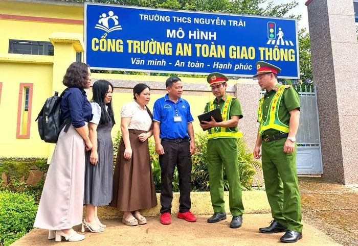 Công an xã Đắk Song phối hợp Trường THCS Nguyễn Trãi đẩy mạnh tuyên truyền cho phụ huynh chấp hành quy định an toàn giao thông tại cổng trường. (Ảnh: TT)