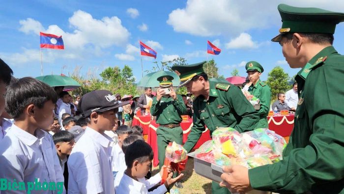 Đại tá Đinh Xuân Hùng, Chính ủy Bộ đội Biên phòng tỉnh Quảng Trị trao tặng quà cho các cháu học sinh hai bên biên giới. Ảnh: Đình Tiến