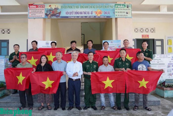 Đại diện Ban Chỉ huy Bộ đội Biên phòng tỉnh Đắk Lắk và chính quyền địa phương trao cờ Tổ quốc tặng ngư dân. Ảnh: Ngũ Tố