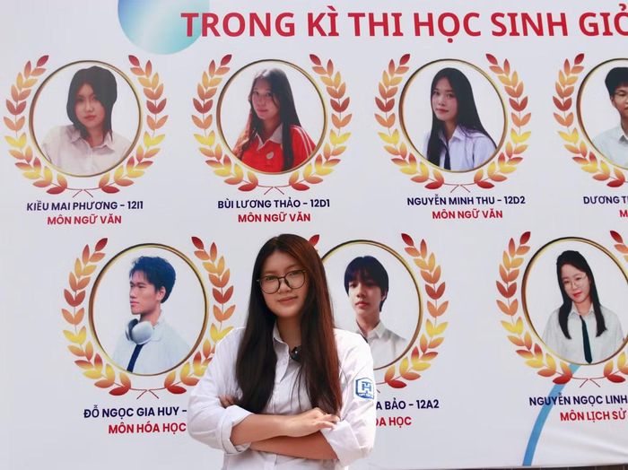 Nữ sinh bên bảng vinh danh của nhà trường sau khi trở thành thủ khoa kỳ thi học sinh giỏi thành phố môn Ngữ văn. (ảnh: Mai Linh)