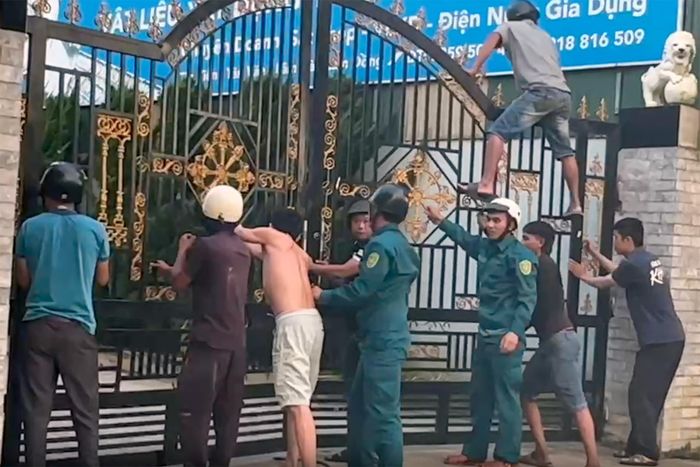 Nhiều người cùng giữ cổng để ngăn con trâu thoát ra ngoài. Ảnh: Thái Ngọc