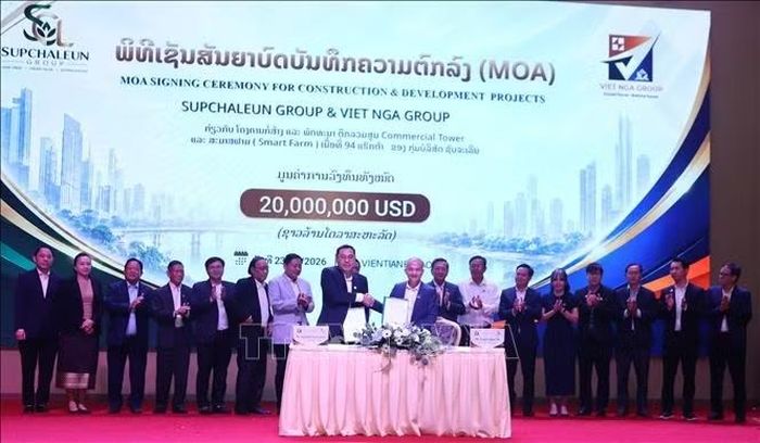 Lãnh đạo hai Tập đoàn trao Biên bản thỏa thuận hợp tác (MOA) và bắt tay chúc mừng sự thành công của Lễ ký kết. Ảnh: Xuân Tú/PV TTXVN tại Lào