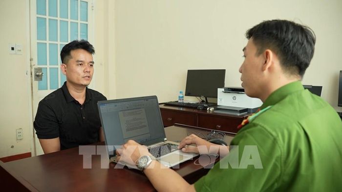 Lấy lời khai đối tượng. Ảnh: TTXVN phát