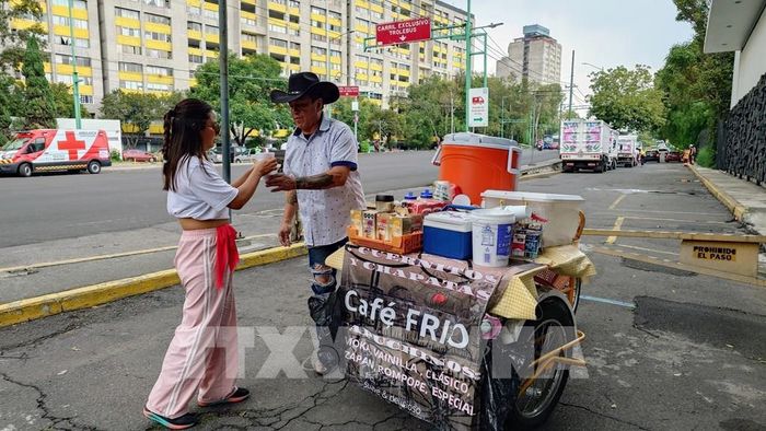 Juan giao cho khách hàng ly cà phê vị mazapán mang vị truyền thống của Mexico. Ảnh: Phi Hùng - PV TTXVN tại Mexico