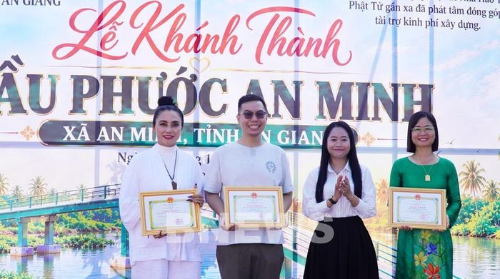Bà Trương Thị Như Ngọc, Phó Chủ tịch UBND xã An Minh tặng Giấy khen cho các mạnh thường quân hỗ trợ kinh phí xây dựng cầu Phước An Minh. Ảnh: Văn Sĩ - TTXVN