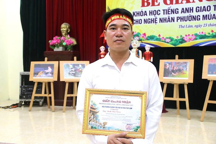 Nghệ nhân Đinh Văn Chiến được trao giấy chứng nhận khi kết thúc khóa học tiếng Anh giao tiếp.