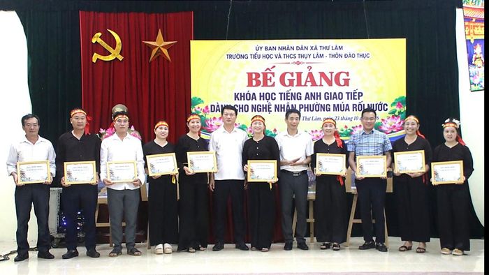 Các nghệ nhân Phường Múa rối nước Đào Thục (xã Thư Lâm, Hà Nội) được trao giấy chứng nhận khóa học tiếng Anh giao tiếp tại buổi Lễ bế giảng.