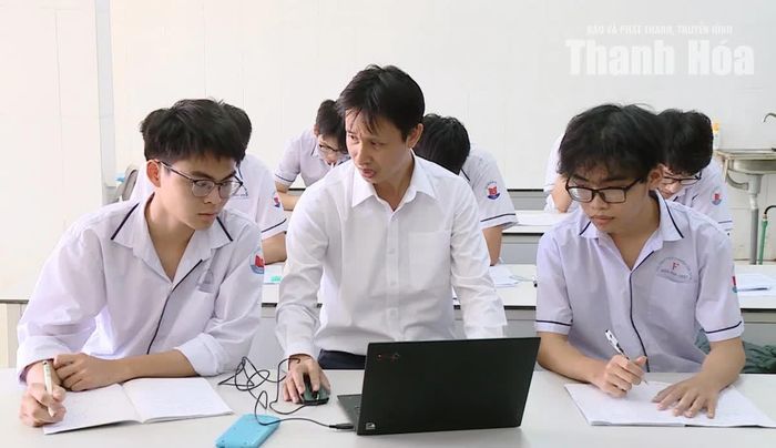 Thầy giáo Nguyễn Bá Tư và hai học sinh của mình.