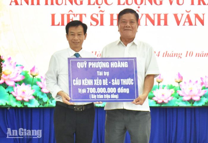 Chủ tịch Hội Bảo trợ Bệnh nhân nghèo tỉnh An Giang Trương Thắng Trận (bên phải) trao bảng tượng trưng tài trợ 700 triệu đồng xây dựng cầu Kênh Xẻo Bè - Sáu Thước.