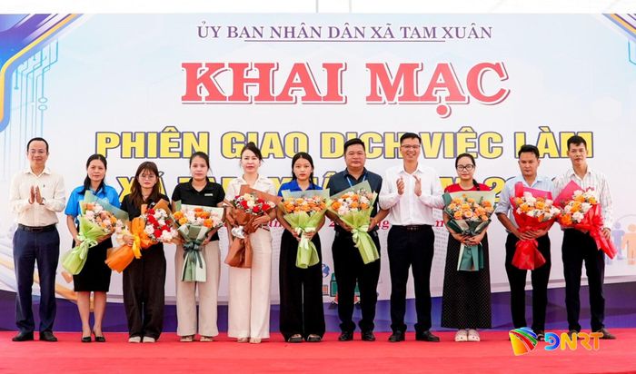 Lãnh đạo Sở Nội vụ và xã Tam Xuân tặng hoa cảm ơn các doanh nghiệp, cơ quan, đơn vị đồng hành với phiên giao dịch việc làm. Ảnh: HỒ QUÂN