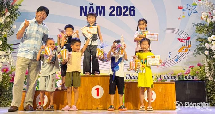 Nhạc sĩ Đỗ Diệp Hoài Anh (bìa trái) trao giải cho các em học sinh tham gia Hội thi Tiếng hát học sinh năm 2026 trên địa bàn phường Long Thành.