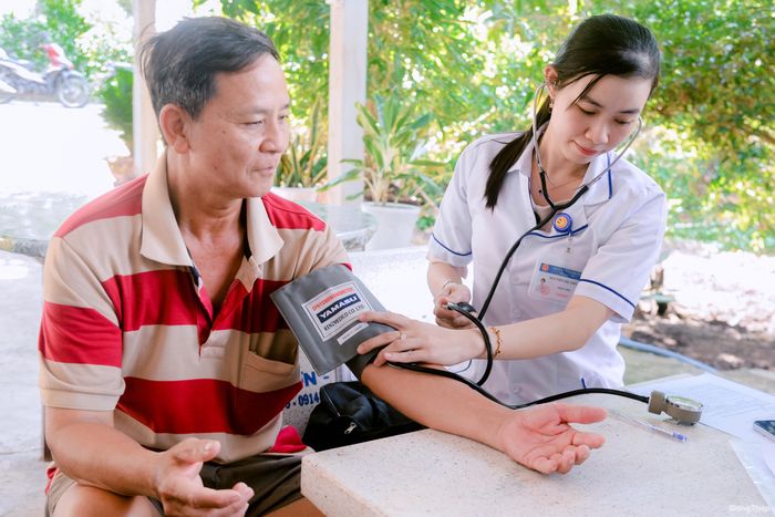 Nhân viên Trạm Y tế xã Tân Phước 1 khám sức khỏe tại nhà cho người dân.
