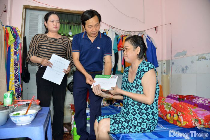 Đồng chí Nguyễn Trọng Tấn, Phó Giám đốc Báo và phát thanh, truyền hình Đồng Tháp, thăm hỏi và trao tiền hỗ trợ của bạn đọc đến chị Nguyễn Thị Thùy Trang.