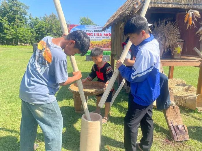  Các em học sinh trải nghiệm giã gạo. Ảnh: Vũ Chi 