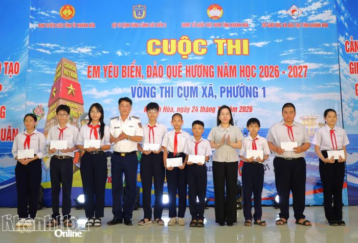 Đồng chí Hà Hồng Hạnh và Đại tá Nguyễn Hồng Chuyên trao học bổng cho các học sinh.