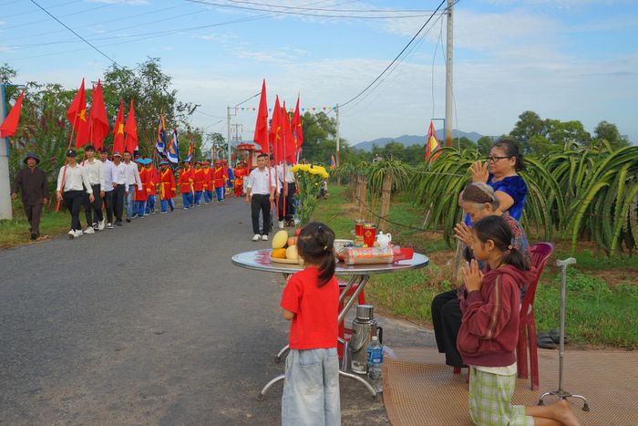 Người dân địa phương dâng hương khi đoàn rước lễ đi qua