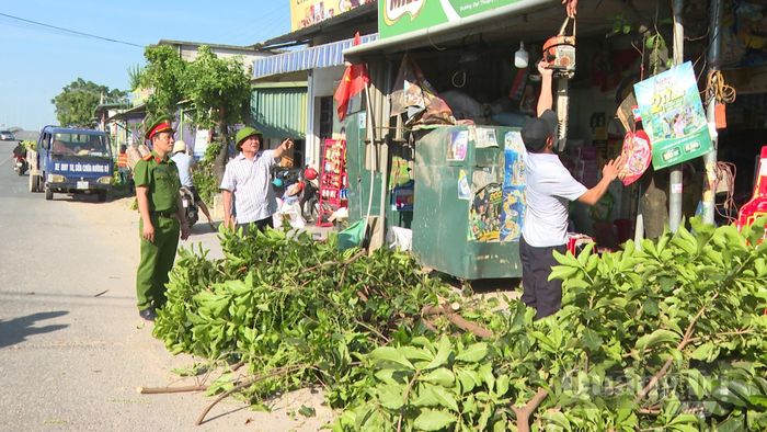 Tháo dỡ các biển hiệu, vật kiến trúc ảnh hưởng lối đi trên hành lang đường bộ - Ảnh: Q.N