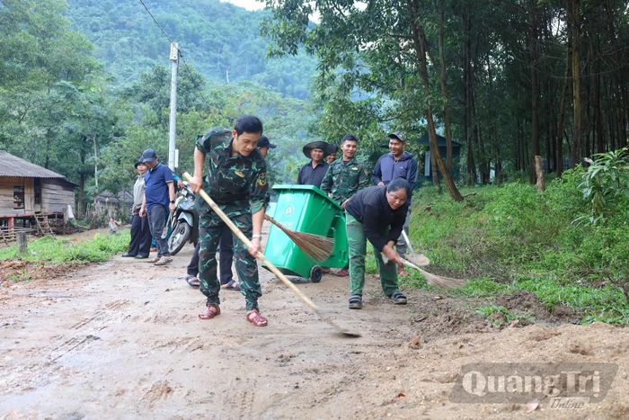 Cán bộ xã Dân Hóa cùng người dân tham gia nạo vét cống rãnh, dọn đất bùn trên đường, góp phần giữ gìn vệ sinh môi trường, xây dựng bản làng sáng, xanh, sạch, đẹp - Ảnh: Q.N.