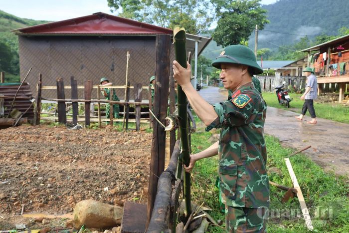 Cán bộ, chiến sĩ Bộ đội Biên phòng cùng người dân bản Lòm-K.Chăm, xã Dân Hóa xây dựng hàng rào, chỉnh trang khuôn viên, từng bước hình thành vườn nhà gọn gàng, sạch đẹp - Ảnh: Q.N.