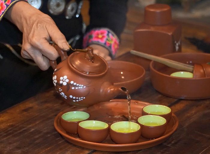 Chén trà nóng được rót mời khách, mở đầu câu chuyện thân tình bên bếp lửa Thái Hải.