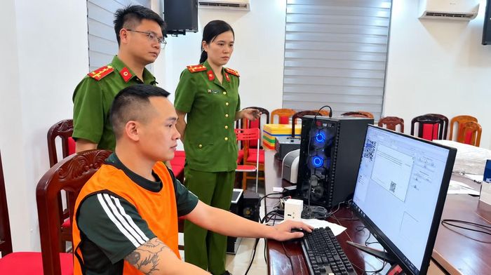 Một đối tượng đang thực hiện lại thao tác in giấy tờ giả dưới sự giám sát của cơ quan Công an.
