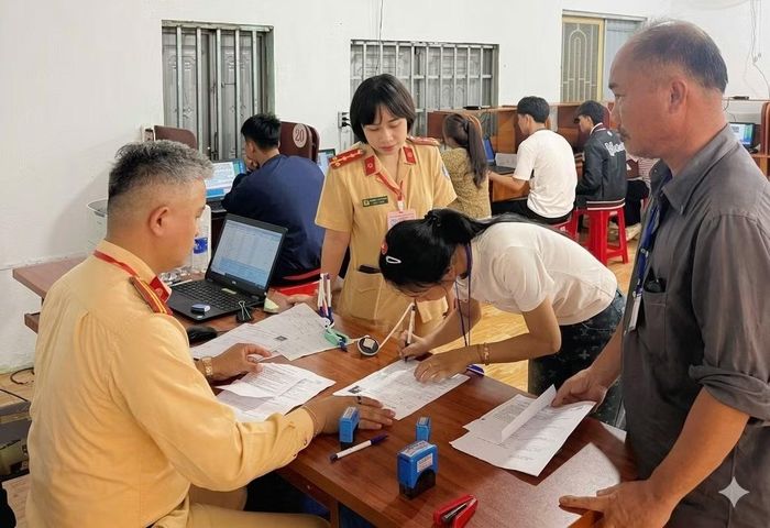 Cán bộ, chiến sĩ Phòng CSGT tỉnh Gia Lai hỗ trợ người dân làm thủ tục thi sát hạch cấp giấy phép lái xe.