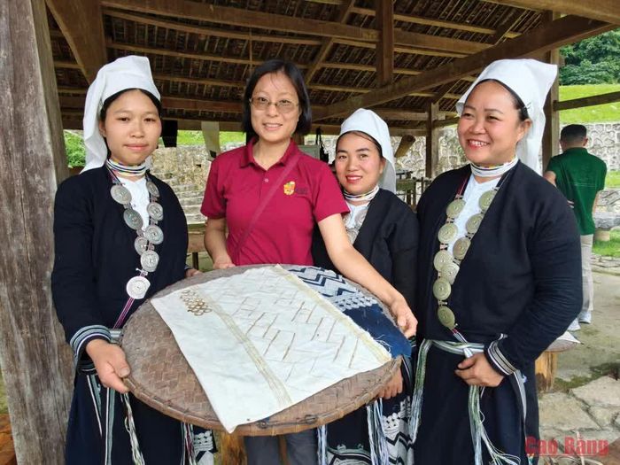 Du khách trải nghiệm in hoa văn bằng sáp ong của đồng bào Dao Tiền tại Làng du lịch cộng đồng Hoài Khao.
