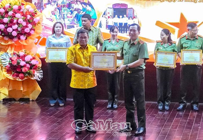 Ông Kim Miên (áo vàng), Phó Chủ nhiệm Câu lạc bộ “3 tích cực trong đồng bào dân tộc Khmer” xã Hưng Hội, nhận Bằng khen của Bộ trưởng Bộ Công an tại hội nghị.