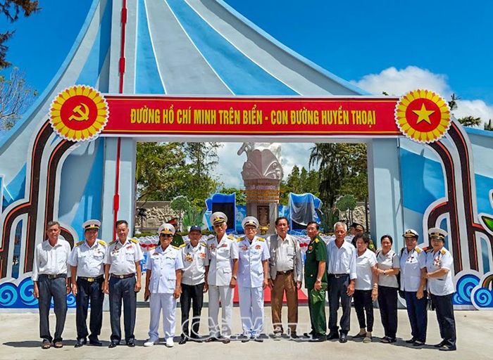 Các cựu chiến binh Đoàn 962 và tàu không số chụp ảnh lưu niệm tại Tượng đài Bến Vàm Lũng.