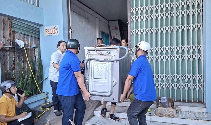 Đoàn viên hỗ trợ người dân di dời các thiết bị điện tử ra khu vực an toàn.