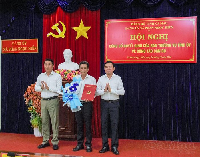 Đồng chí Phan Thanh Duy, Uỷ viên Ban Thường vụ Tỉnh uỷ, Trưởng Ban Tổ chức Tỉnh uỷ (bên phải), trao quyết định và đồng chí Trần Minh Đẳng, Phó Bí thư Thường trực Đảng uỷ Xã Phan Ngọc Hiển tặng hoa chúc mừng đồng chí Lê Bình Nguyên.