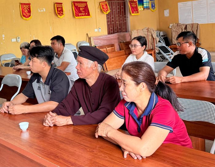 Cô Nguyễn Thị Chính (áo đỏ) trong một buổi họp tại địa phương. Ảnh: ĐỨC ANH