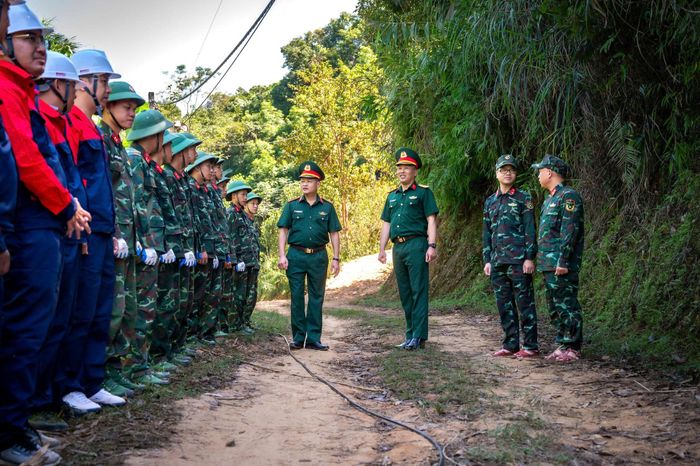 Đại tá Đàm Sĩ Bách (thứ 4 từ bên phải) đến thăm, động viên cán bộ, chiến sĩ thực hiện nhiệm vụ kéo dây cáp tại xã Tân Tiến, Lạng Sơn. (Ảnh: VH)