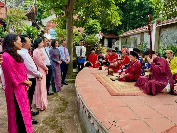 Phó Chủ tịch UBND thành phố Hà Nội Vũ Thu Hà và các đại biểu xem các nghệ nhân ca trù biểu diễn tại đình Quán La. Ảnh: Hoàng Lân.
