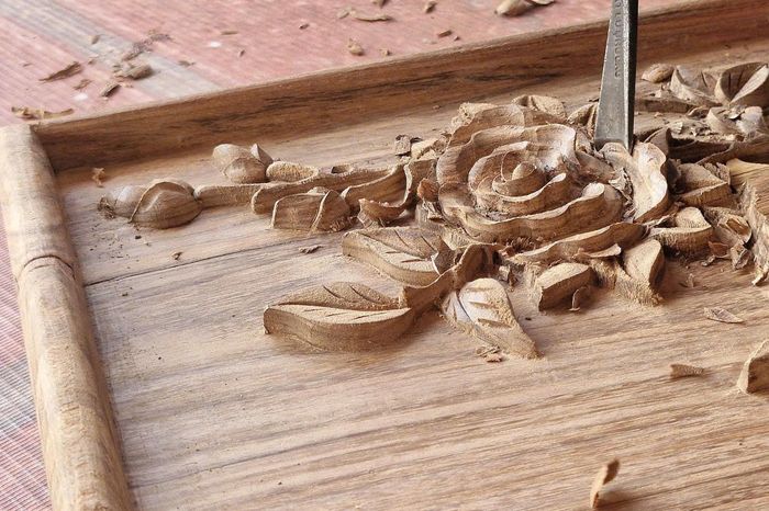 Với tâm huyết giữ nghề truyền thống, các nghệ nhân, thợ giỏi ở làng nghề mộc cao cấp Vạn Điểm nỗ lực trổ tài, thổi hồn vào từng bức tranh, tạo ra những bông hoa hồng đẹp trên chất liệu gỗ. Ảnh: PV