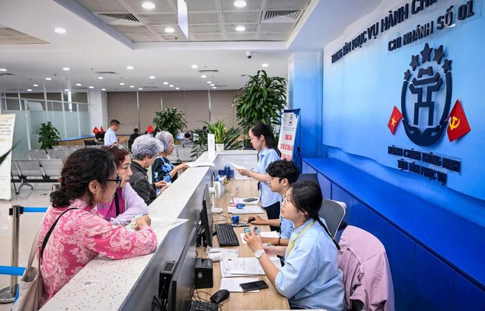 Cán bộ Chi nhánh số 01 - Trung tâm Phục vụ hành chính công thành phố Hà Nội hướng dẫn công dân cao tuổi thực hiện TTHC. Ảnh: PV