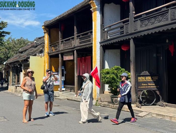 Khách du lịch quốc tế chụp ảnh lưu niệm trước nhà cổ Phùng Hưng. Ảnh: Bích Vân