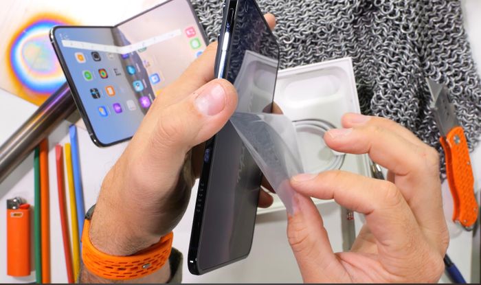  Bài thử độ bền bao gồm cả bước xé tấm dán nano texture trên iPhone Duo, hành động người dùng không được lặp lại nếu không muốn phá hỏng điện thoại của mình. Ảnh: JerryRigEverything. 