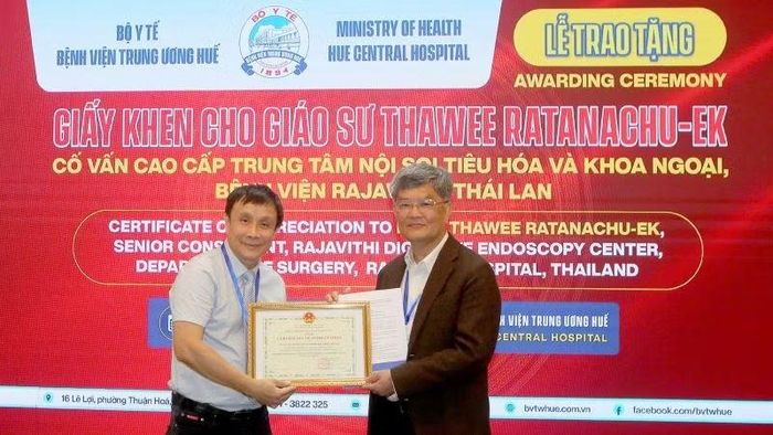 Đại diện Ban tổ chức tặng giấy khen cho Giáo sư Thawee Ratanachu-Ek, Cố vấn cao cấp Nội soi tiêu hóa và Phẫu thuật ngoại khoa, Bệnh viện Rajavithi (Thái Lan). (Ảnh: BAN TỔ CHỨC)