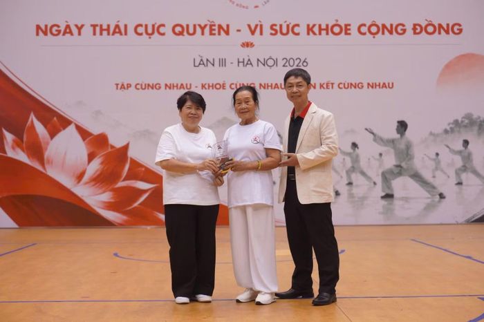 Ban tổ chức trao kỷ niệm chương vinh danh cụ Vũ Thị Liệu (87 tuổi, đến từ Hải Phòng) - minh chứng sinh động cho lối sống "Thân khỏe-Tâm an-Trí sáng" nhờ kiên trì luyện tập Thái cực quyền.