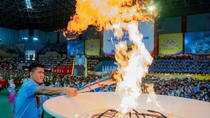Đại diện vận động viên tiêu biểu thắp đuốc truyền thống tại Lễ khai mạc. (Ảnh: L.Hoàng)