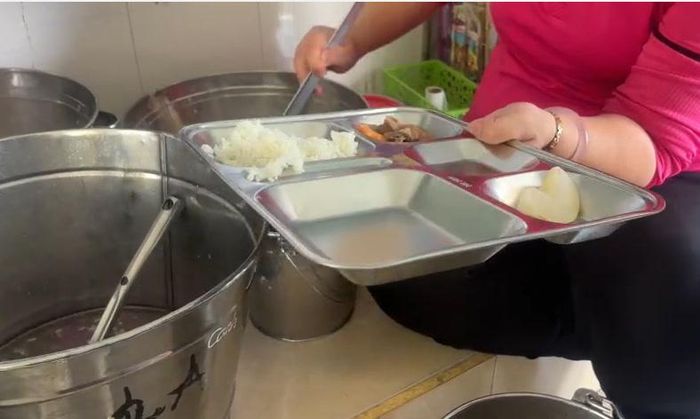  Người chia suất ăn cho các em học sinh không đeo bao tay. Ảnh: Phụ huynh cung cấp 
